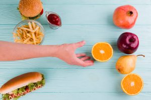 Pessoa escolhendo comer frutas e verduras pois a alimentação afeta a visão.