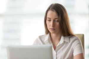 Mulher jovem, com síndrome da visão de computador, trabalhando em seu escritório.