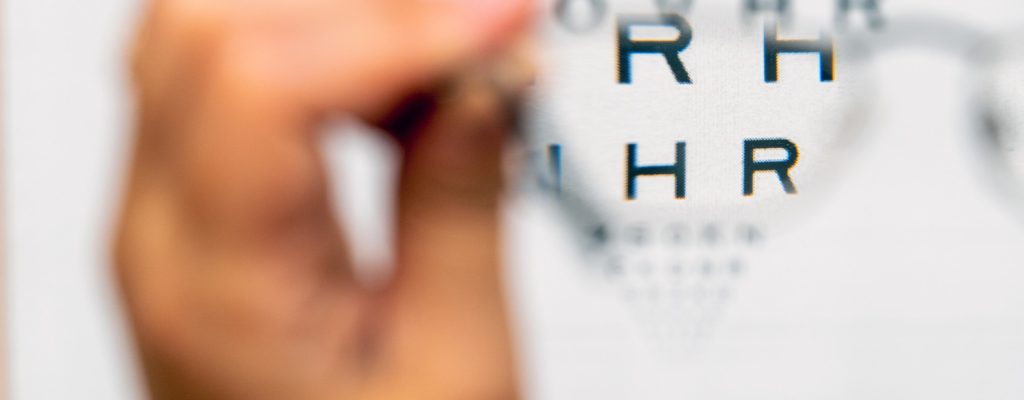 Paciente com hipermetropia testando seus óculos novos no consultório oftalmológico.