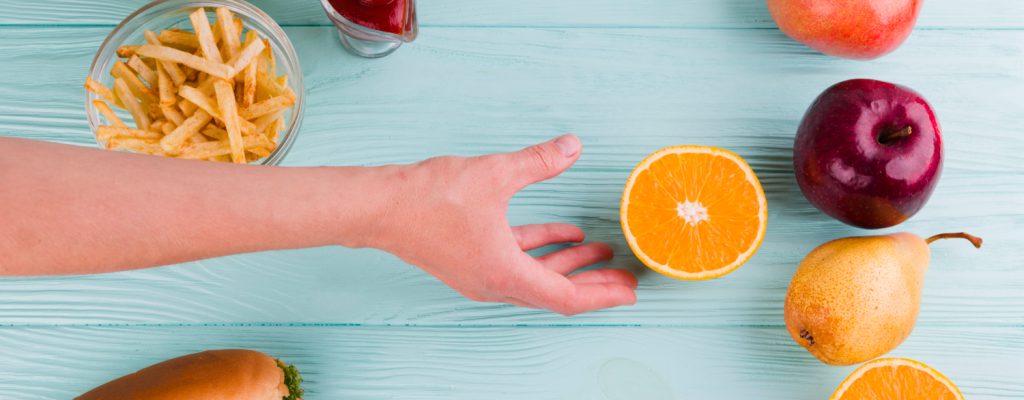 Pessoa escolhendo comer frutas e verduras pois a alimentação afeta a visão.